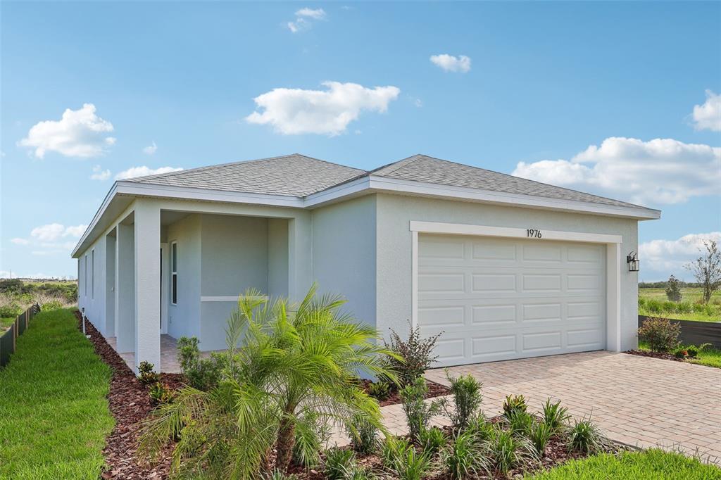 A single-story house with a light-colored stucco exterior, a two-car garage, and a front porch — 1976 DIAMOND HEAD CIRCLE, HAINES CITY, FL