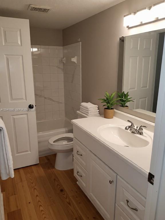A bathroom features a white vanity, a toilet, a tub-shower combo, and wood-look flooring — 738 Crest Pines Dr # 0, Orlando FL 32828, ORLANDO, FL