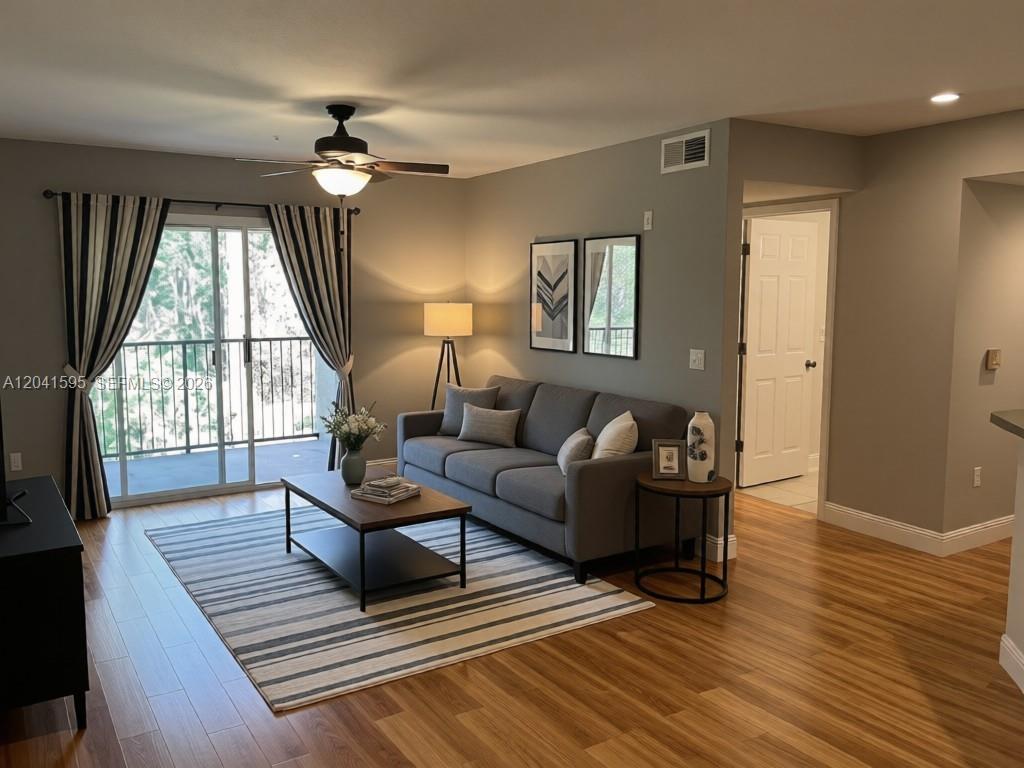 A living room features a gray sofa, striped rug, coffee table, and balcony access — 738 Crest Pines Dr # 0, Orlando FL 32828, ORLANDO, FL