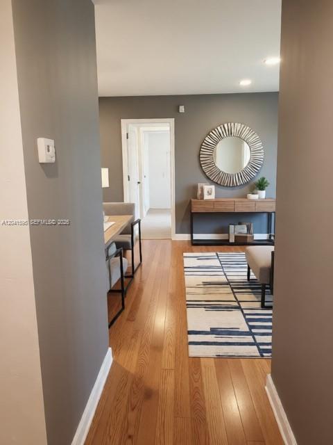A hallway with hardwood floors leads to a dining area and a console table — 738 Crest Pines Dr # 0, Orlando FL 32828, ORLANDO, FL