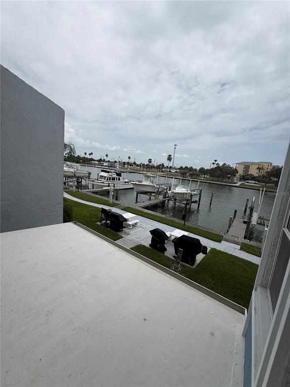 A view from a patio overlooking a canal with several docked boats and grassy areas — 315 MEDALLION BOULEVARD UNIT H, MADEIRA BEACH, FL