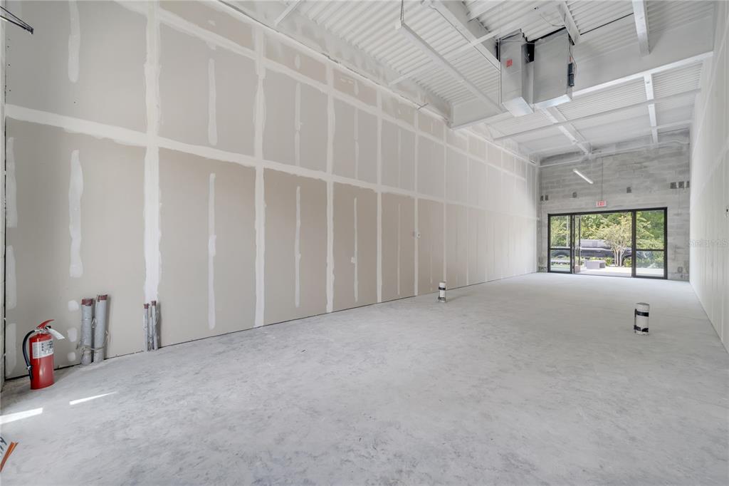An unfinished commercial space features drywall walls, exposed ceiling ductwork, and a concrete floor — 3370 ROUSE ROAD UNIT 102, ORLANDO, FL