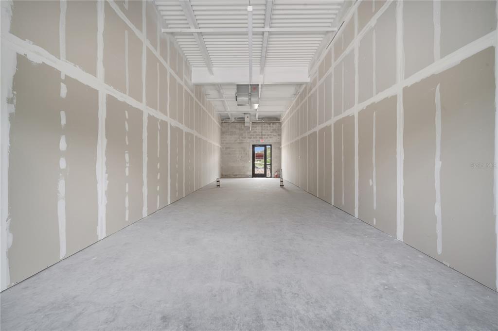 An unfinished commercial space features drywall walls, a concrete floor, and an exposed ceiling — 3370 ROUSE ROAD UNIT 102, ORLANDO, FL
