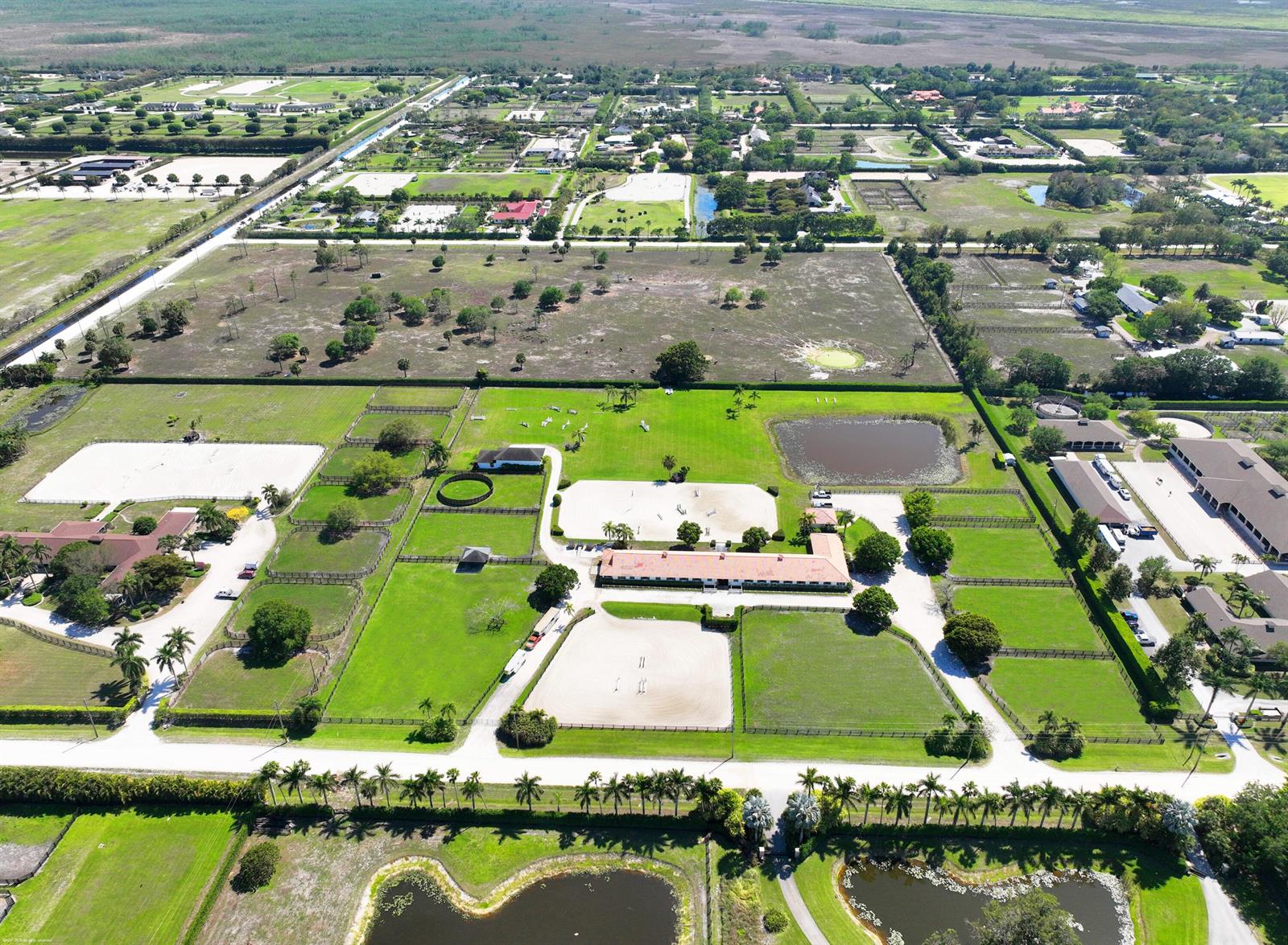 An aerial view shows a large equestrian property with multiple riding arenas, stables, and paddocks — 13122 52nd Place S, Wellington FL 33449, WELLINGTON, FL
