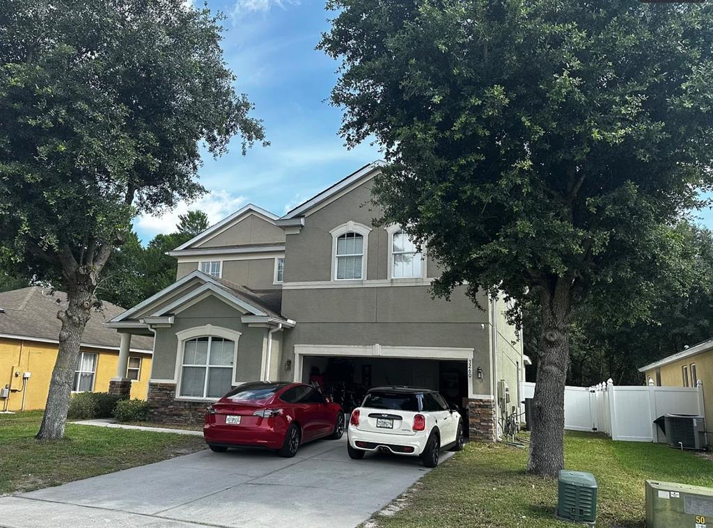 A two-story house with a two-car garage and a driveway containing two parked cars — 3260 SORREL COURT, DELTONA, FL