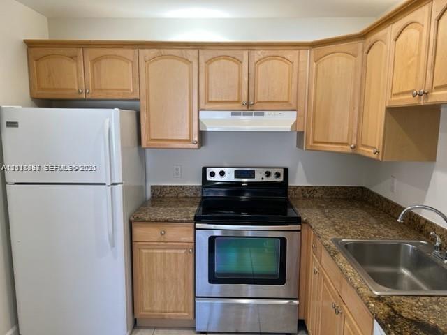 A kitchen features light wood cabinets, granite countertops, and stainless steel appliances — 594 Saxony M # 594, Delray Beach FL 33446, DELRAY BEACH, FL