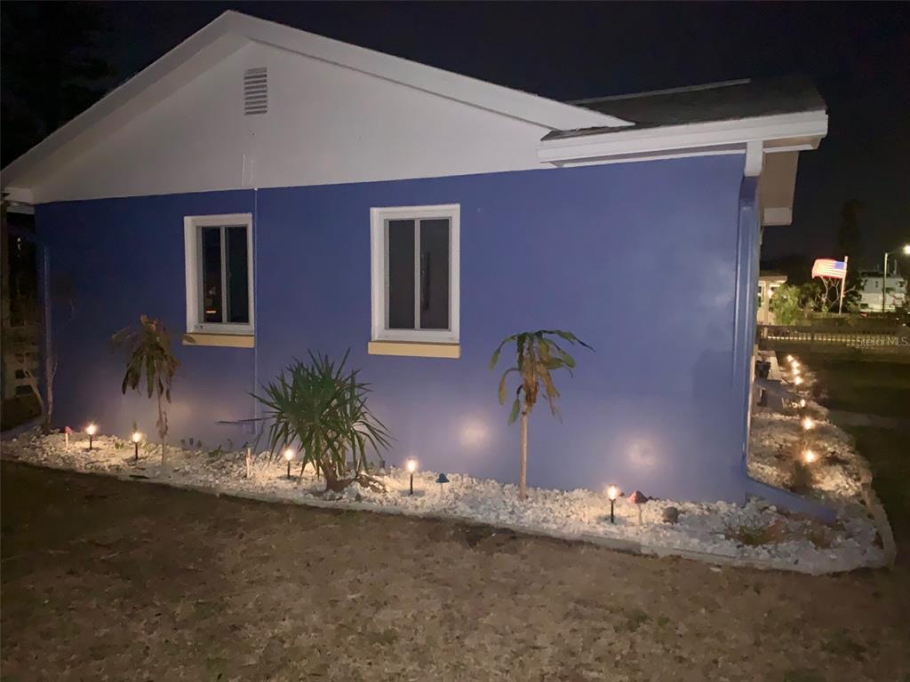 A blue house exterior at night with white gravel landscaping and solar path lights — 2800 TIFTON STREET S, GULFPORT, FL