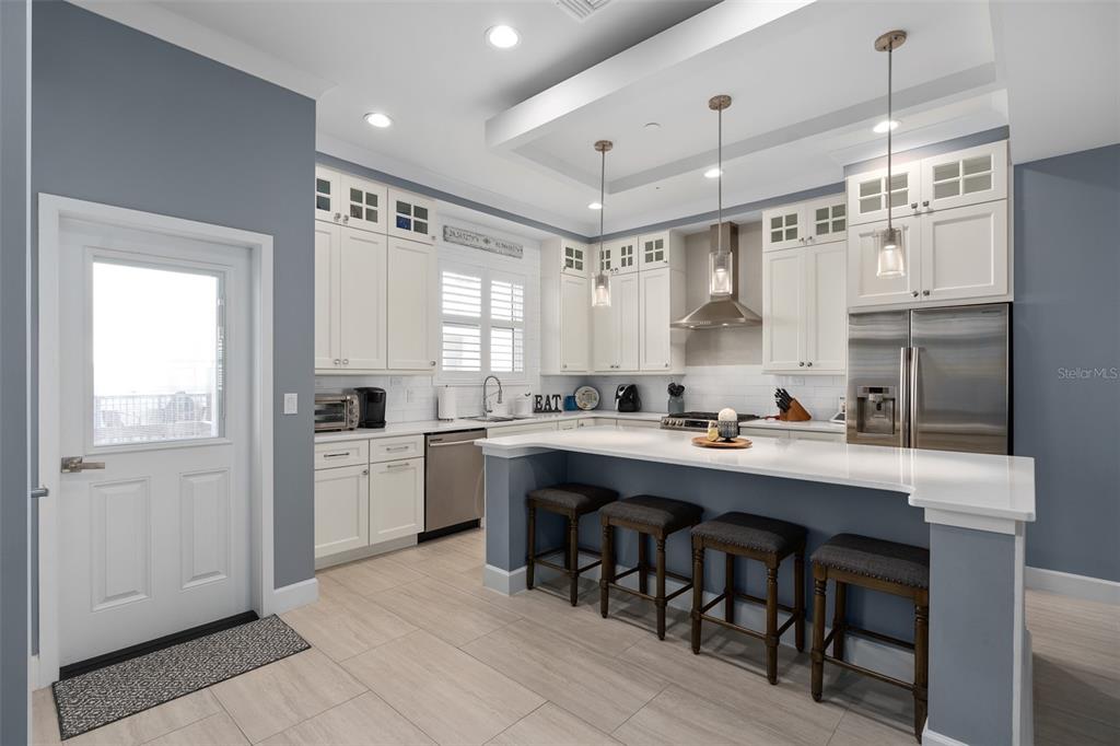 A kitchen with white cabinets, stainless steel appliances, a breakfast bar, and gray walls — 129 S PARK AVENUE, WINTER GARDEN, FL