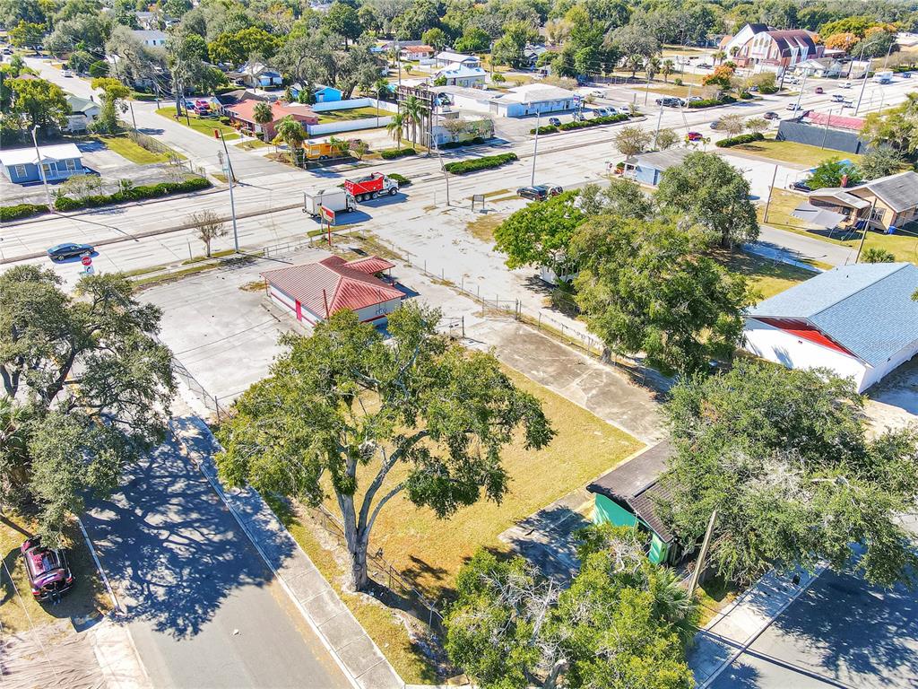 An aerial view shows a commercial lot with a small building and surrounding trees — 305 & 309 W MEMORIAL BOULEVARD, LAKELAND, FL