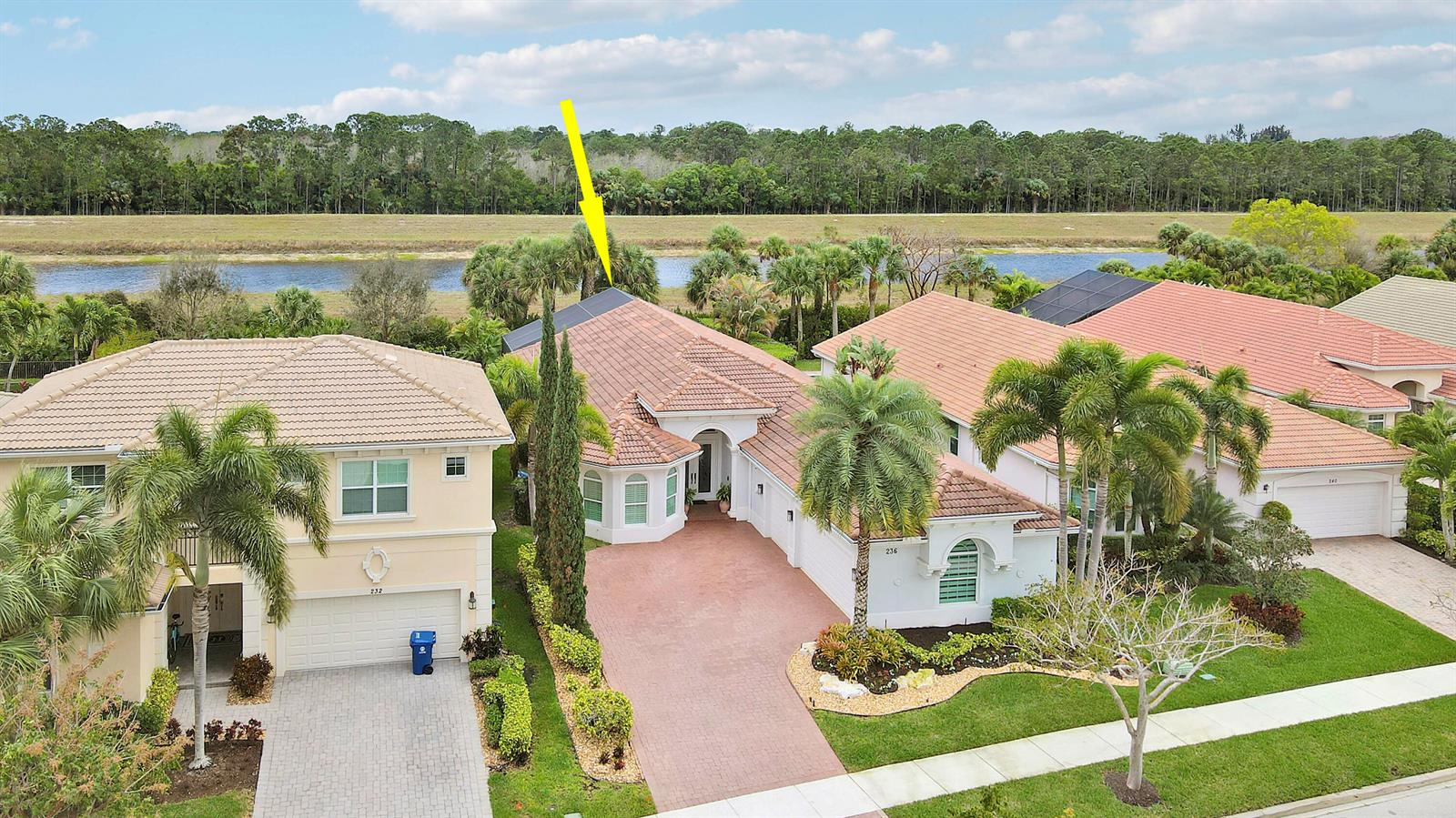 An aerial view shows a suburban house with a tile roof and a paved driveway — 236 Carina Drive, Jupiter FL 33478, JUPITER, FL
