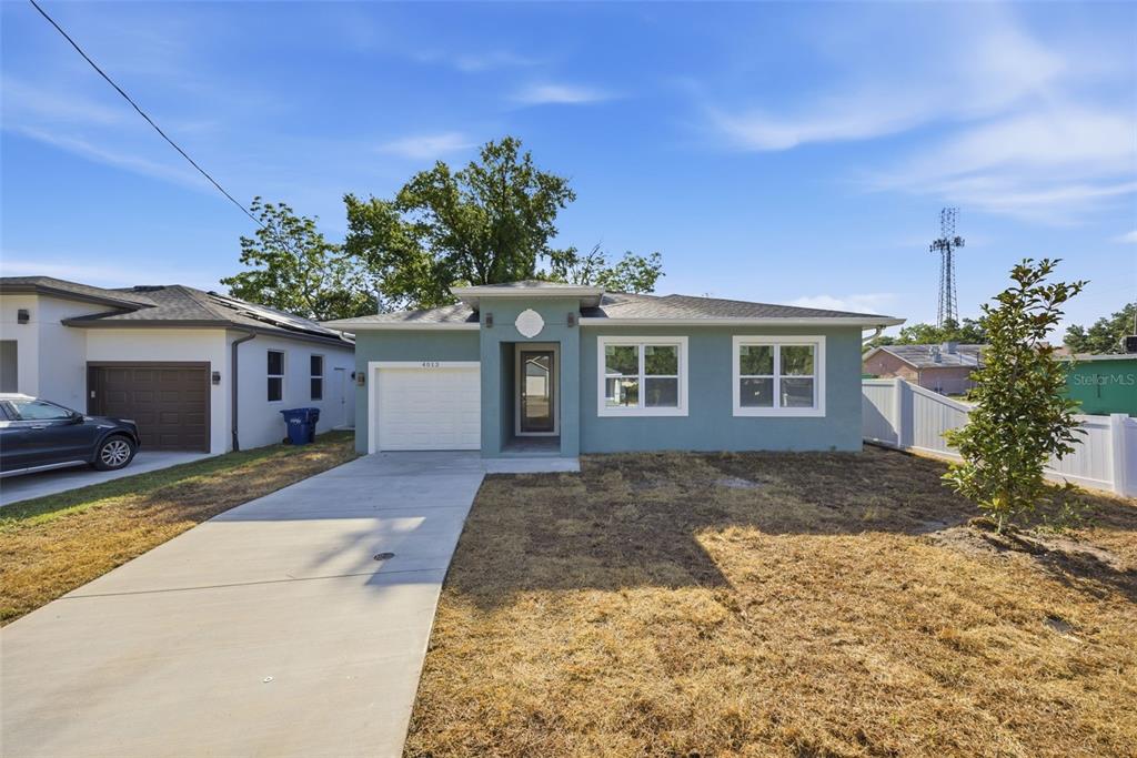 A single-story house with a teal exterior, a concrete driveway, and a small front yard — 4013 N 29TH STREET, TAMPA, FL