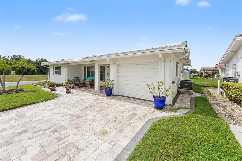 A white house with a paved driveway, a garage, and a covered patio area — 3450 101ST TERRACE N, PINELLAS PARK, FL