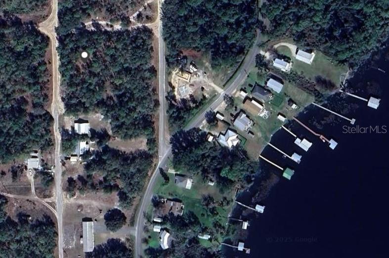 This aerial map view shows a wooded lot, a road, and several homes along a waterfront — 132 SARASOTA STREET, FLORAHOME, FL