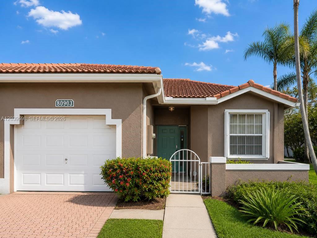 The exterior of a single-story house features a garage, a gated entryway, and a window — 8090 S Aragon Blvd # 3, Sunrise FL 33322, SUNRISE, FL