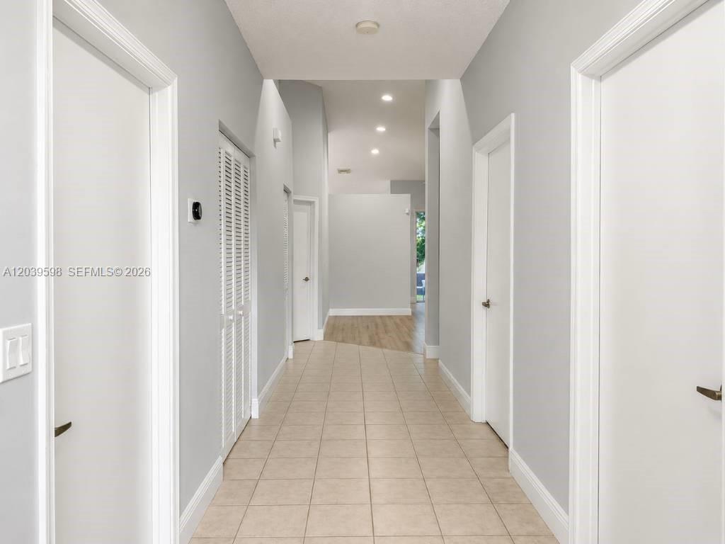 A tiled hallway leads to an open living area with light gray walls and doors — 8090 S Aragon Blvd # 3, Sunrise FL 33322, SUNRISE, FL