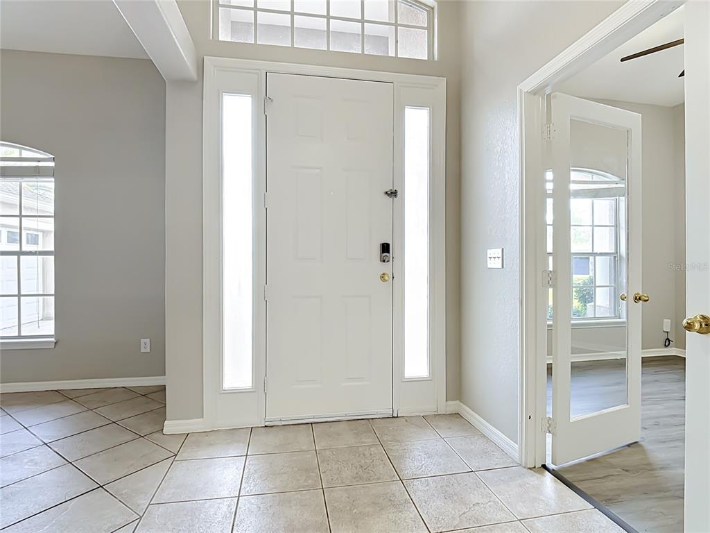 A tiled entryway features a white front door with sidelights and a glass-paned interior door — 3910 COUNTRYSIDE VIEW COURT, ST CLOUD, FL