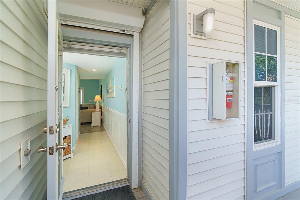 An open doorway reveals a hallway with light blue walls, tile flooring, and a living area — 7446 PALM ISLAND DRIVE UNIT 3511, PLACIDA, FL