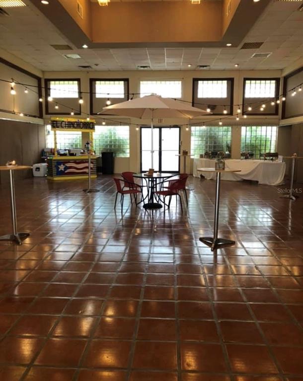 A large, tiled event hall features a central umbrella table, string lights, and a food kiosk — CARR 1,  KM 21.3 BO. LA MUDA, GUAYNABO, PR