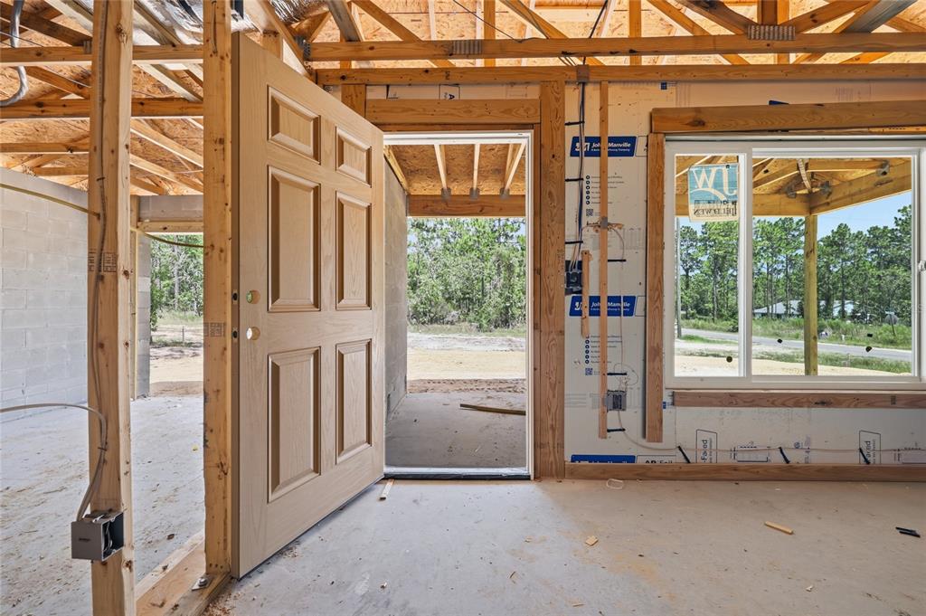 An interior view of a house under construction showing an open door and a window — 760 NE 149 COURT, WILLISTON, FL