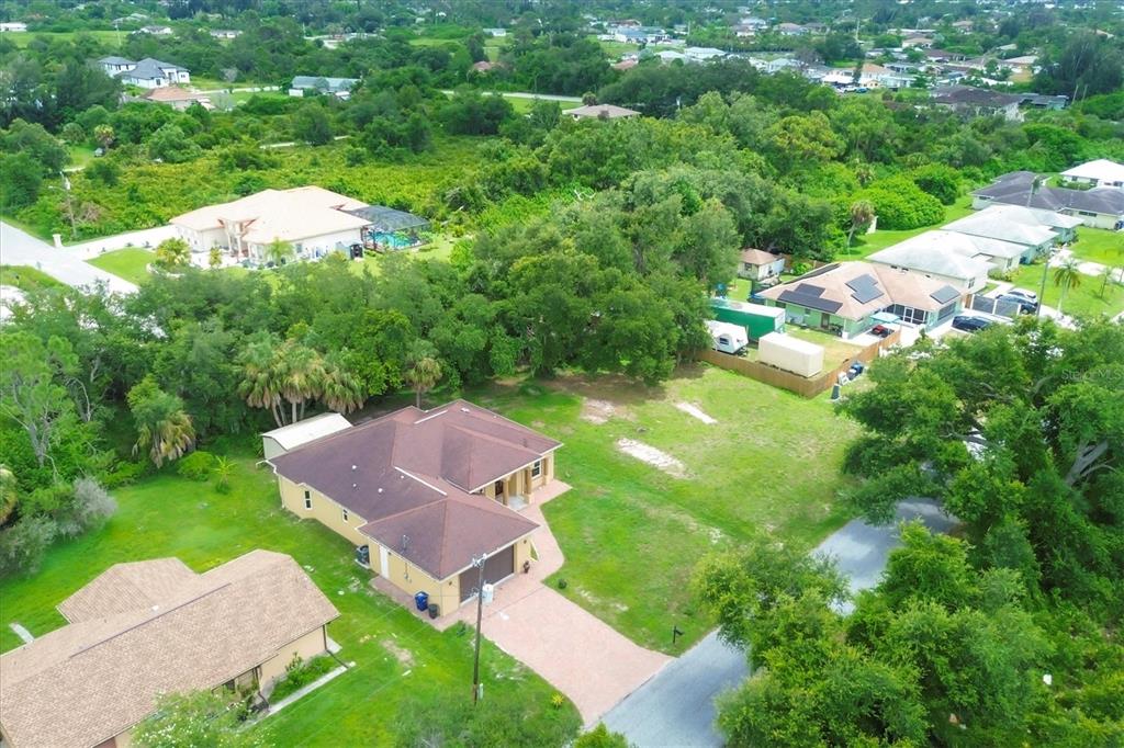 An aerial view shows a yellow house with a brown roof and a paved driveway — 431 SEVILLA STREET, NORTH PORT, FL