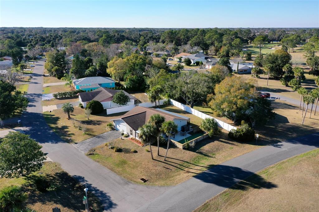 An aerial view shows a suburban house with a fenced yard and palm trees — 15 CLARK LANE, PALM COAST, FL