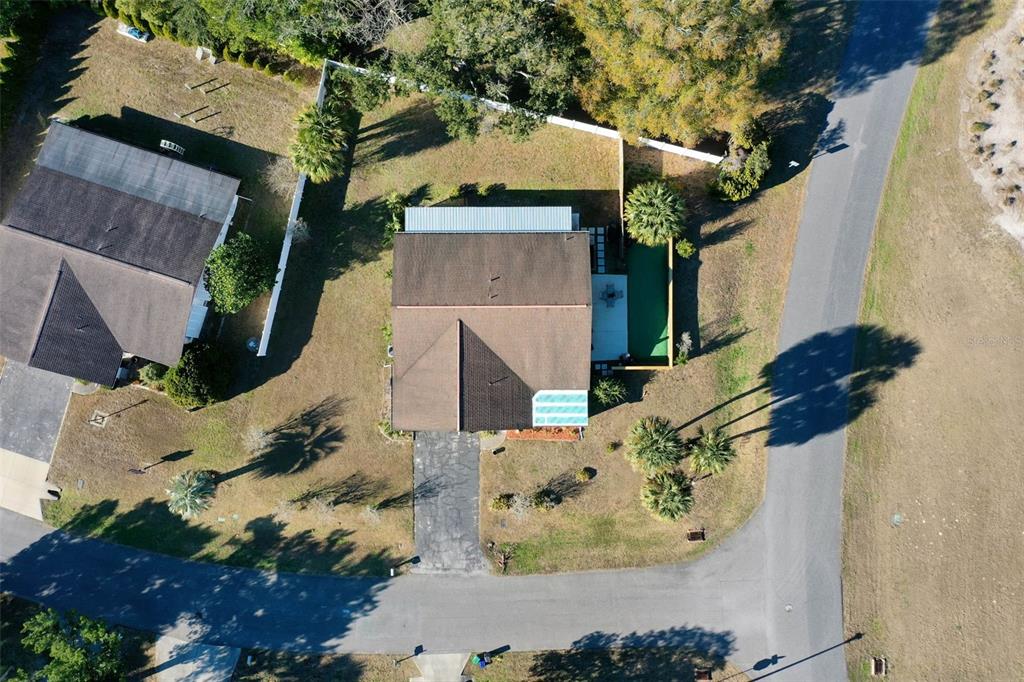 An aerial view shows a house with a brown roof, a driveway, and a backyard — 15 CLARK LANE, PALM COAST, FL
