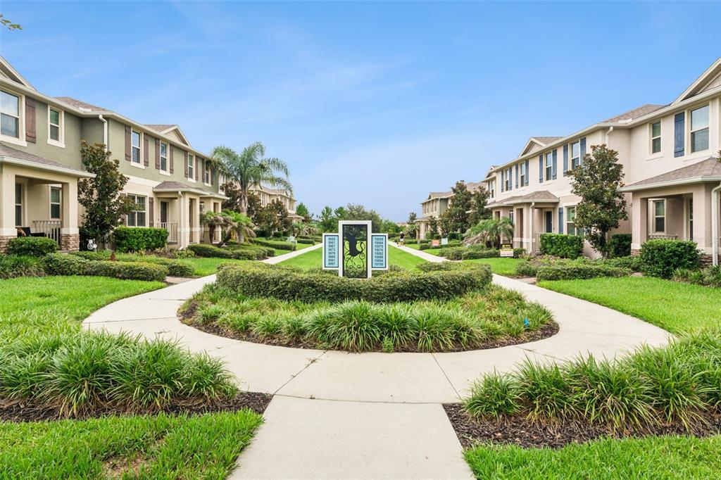 A courtyard with a central directory sign sits between two rows of multi-story residential buildings — 9991 SCHROEDER ALLEY, WINTER GARDEN, FL