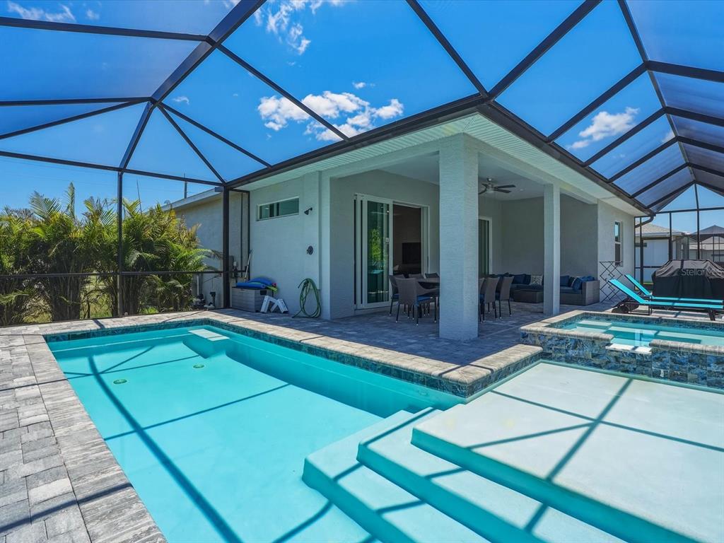 A screened-in patio features a swimming pool, a raised spa, and outdoor dining furniture — 776 ROTONDA CIRCLE, ROTONDA WEST, FL
