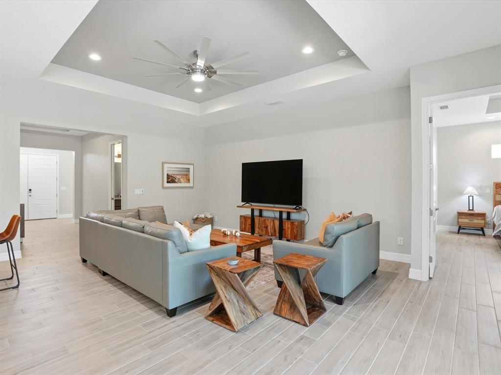 A living room features a tray ceiling, a ceiling fan, and light-colored tile flooring — 776 ROTONDA CIRCLE, ROTONDA WEST, FL