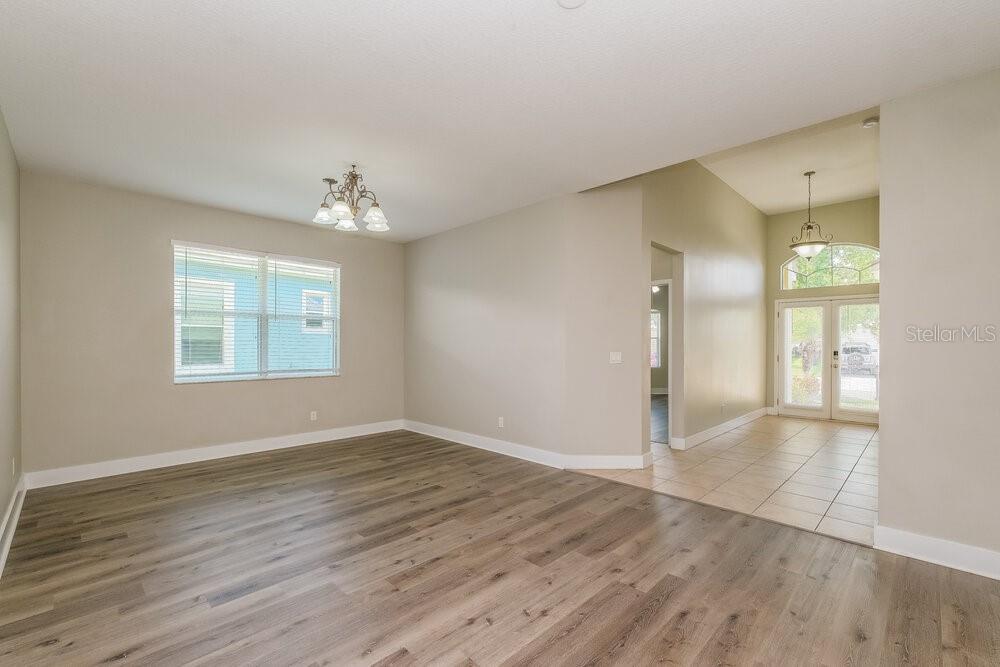 A dining room with wood-look flooring, a chandelier, and an entryway with tiled floors — 569 BIMINI BAY BOULEVARD, APOLLO BEACH, FL