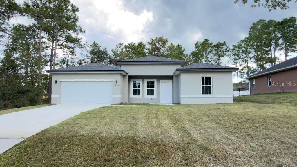 A single-story house with a white garage, gray exterior, and a front entrance — 2674 W PINTADO DRIVE, CITRUS SPRINGS, FL