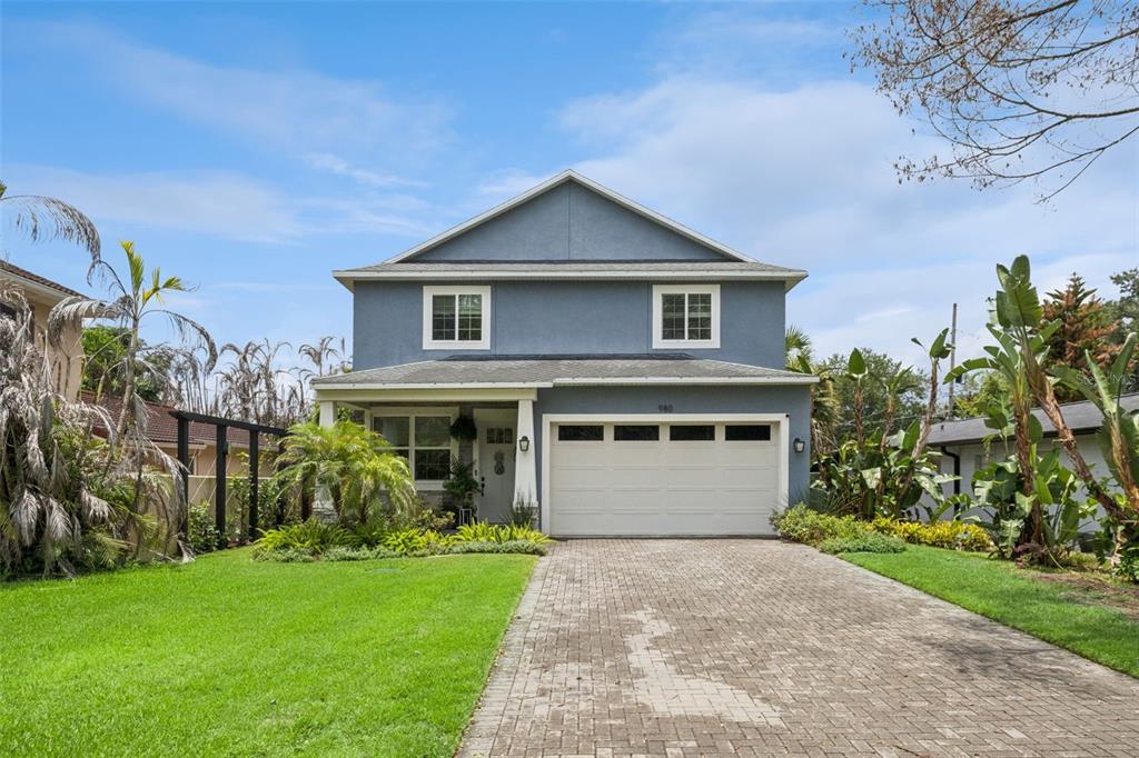 A two-story blue house features a paved driveway, a two-car garage, and a front porch — 980 BURNS STREET, ORLANDO, FL