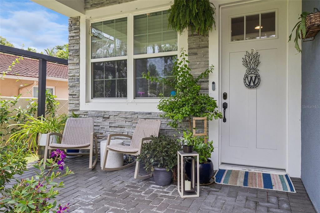 A front porch features two rocking chairs, potted plants, and a white door with a pineapple — 980 BURNS STREET, ORLANDO, FL