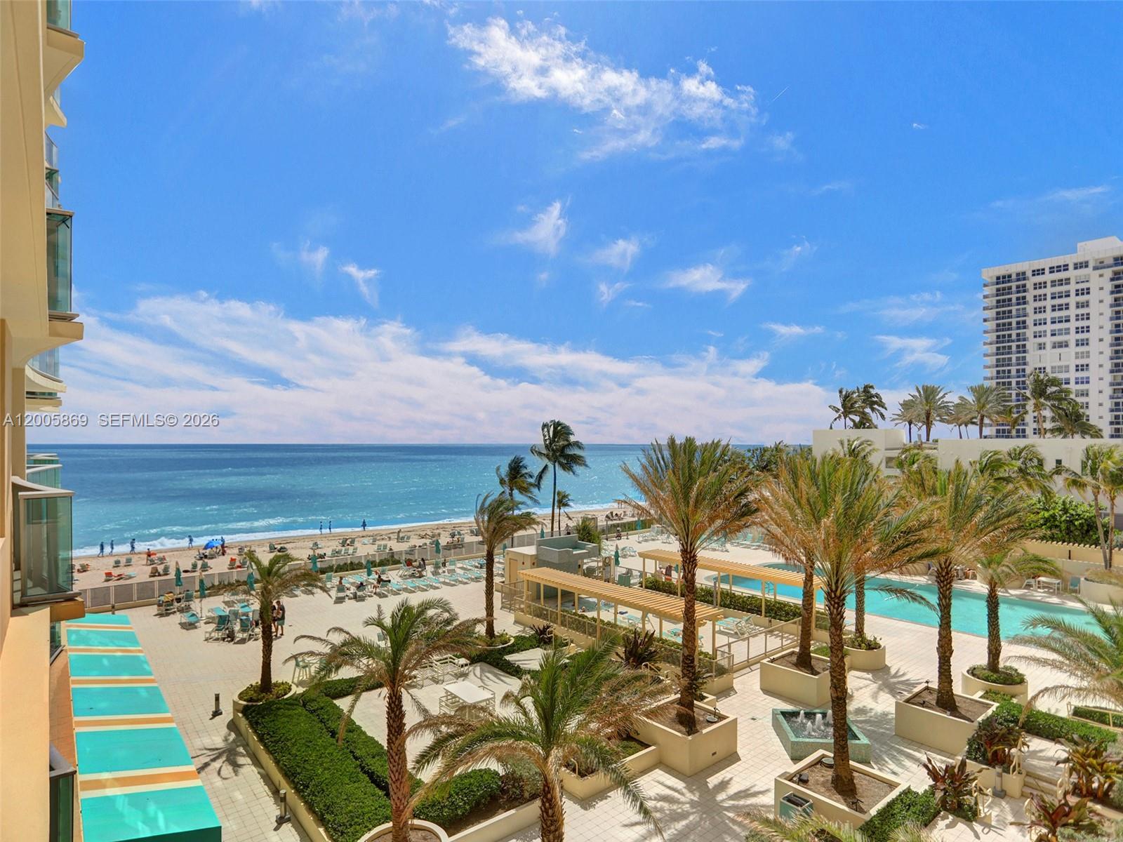 An elevated view shows a resort pool deck, palm trees, and a beach with ocean — 2501 S Ocean Dr # 415, Hollywood FL 33019, HOLLYWOOD, FL