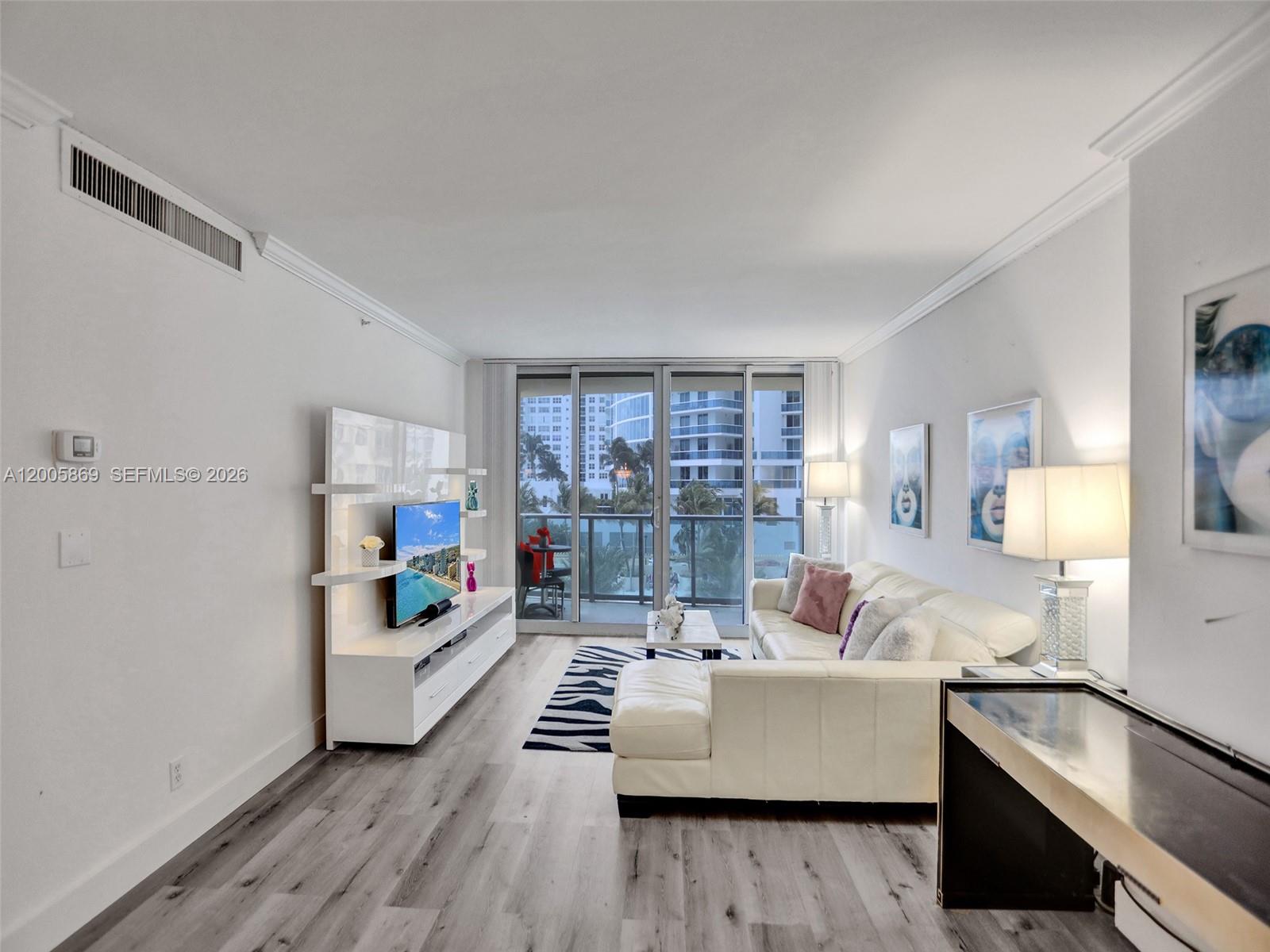 A living room features white furniture, a zebra-print rug, and a balcony with city views — 2501 S Ocean Dr # 415, Hollywood FL 33019, HOLLYWOOD, FL