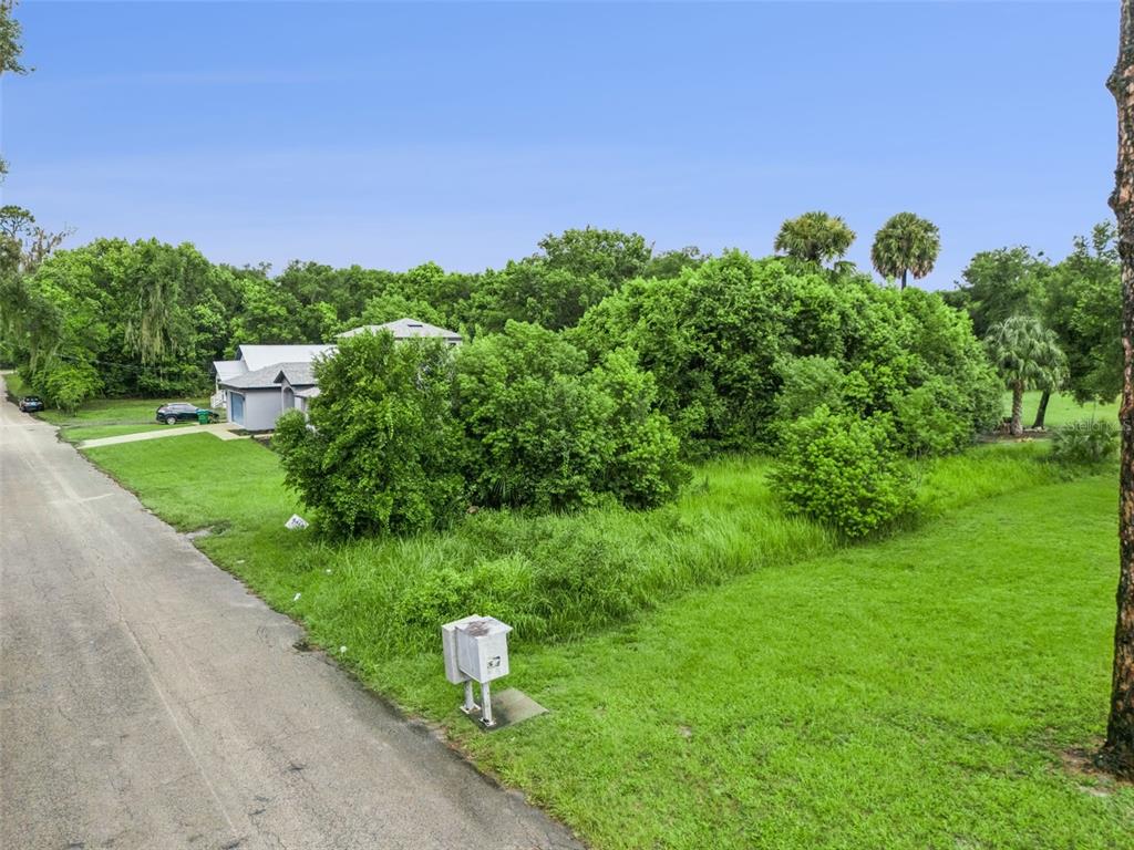 An aerial view shows a grassy lot with a mailbox next to a paved road — S GOODWIN STREET, LAKE HELEN, FL