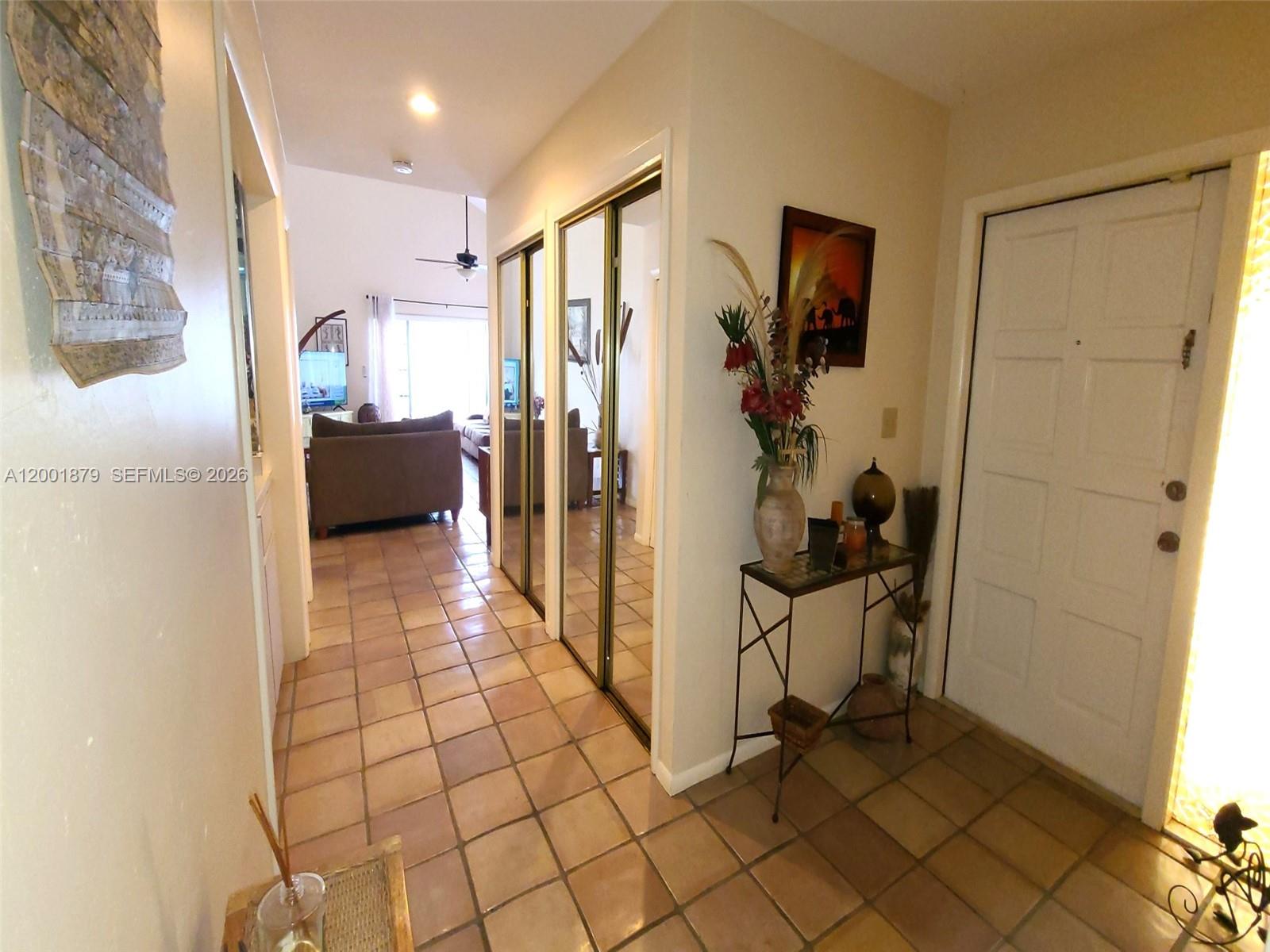 A tiled entryway leads to a living area with mirrored closet doors and a console table — 5524 Constant Spring Ter # 213, Lauderhill FL 33319, LAUDERHILL, FL