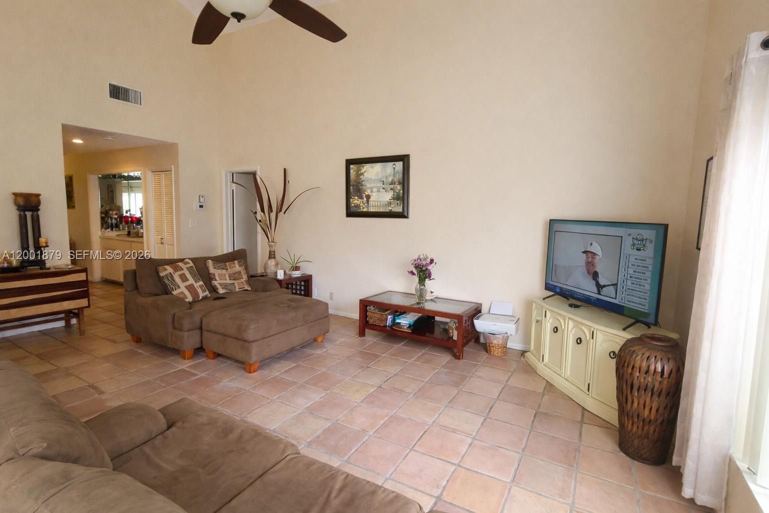 A living room features tile floors, a vaulted ceiling, and a television on a console — 5524 Constant Spring Ter # 213, Lauderhill FL 33319, LAUDERHILL, FL