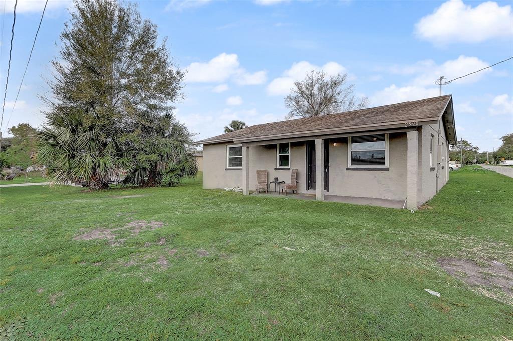 A single-story house with a covered front porch sits on a grassy lot — 2590 E STATE ROAD 46, SANFORD, FL