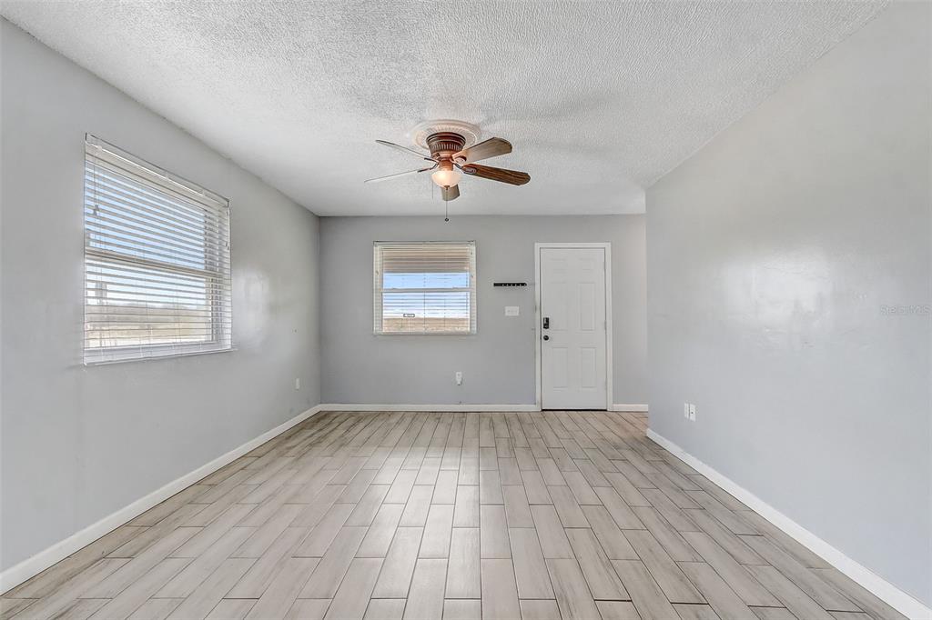 An empty room features light gray walls, wood-look tile flooring, and a ceiling fan — 2590 E STATE ROAD 46, SANFORD, FL