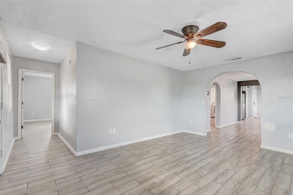 A living area with light gray walls, wood-look tile flooring, and a ceiling fan — 2590 E STATE ROAD 46, SANFORD, FL