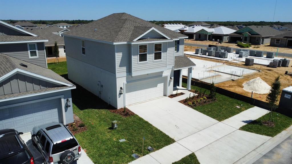 An aerial view shows a two-story suburban house with a garage and a concrete driveway — 441 SANDBAR LANE, HAINES CITY, FL