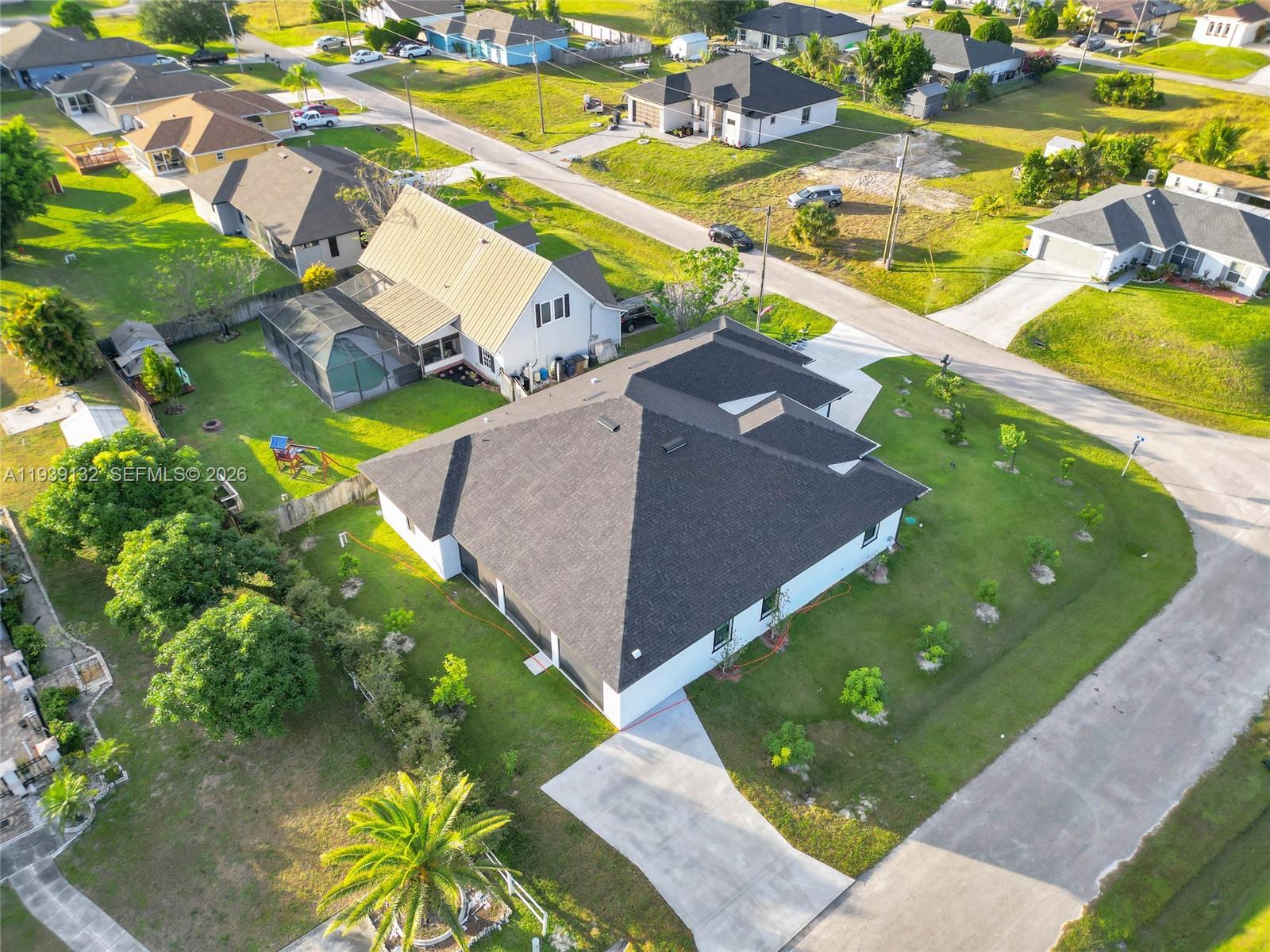 An aerial view shows a suburban neighborhood with several single-family homes and paved streets — 4301 10th ST W, Lehigh Acres FL 33971, LEHIGH ACRES, FL