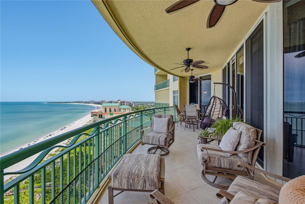 A balcony with outdoor furniture overlooks a sandy beach and the ocean — 940 CAPE MARCO DRIVE UNIT 1905, MARCO ISLAND, FL