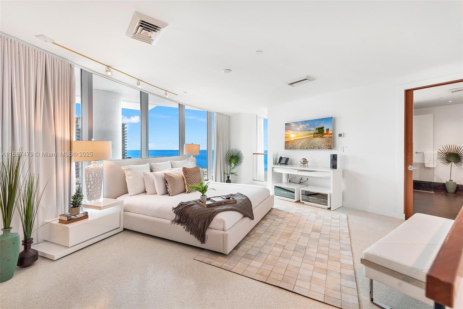 A modern bedroom features a king bed, floor-to-ceiling windows with ocean views, and white furniture — 101 20th St Th B # 1505, Miami Beach FL 33139, MIAMI BEACH, FL