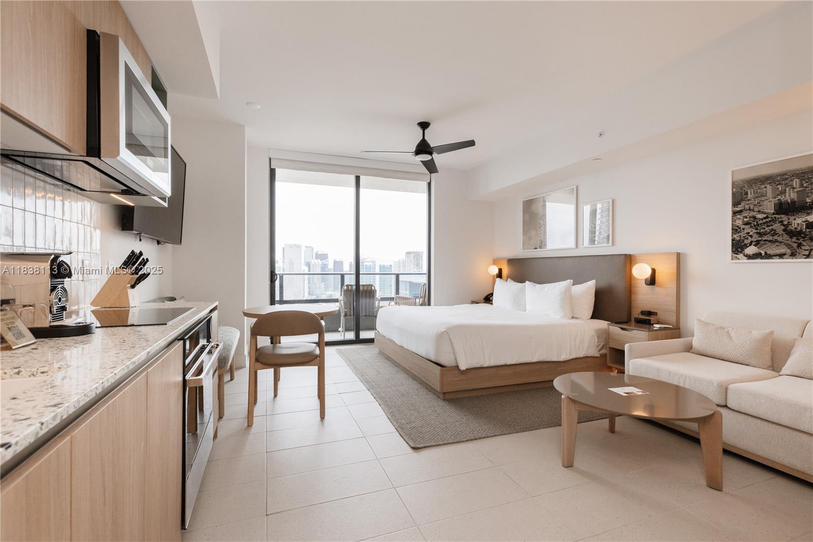 A modern studio apartment features a kitchenette, a bed, a sofa, and a balcony view — 601 NE 1st ave # 3612, Miami FL 33132, MIAMI, FL