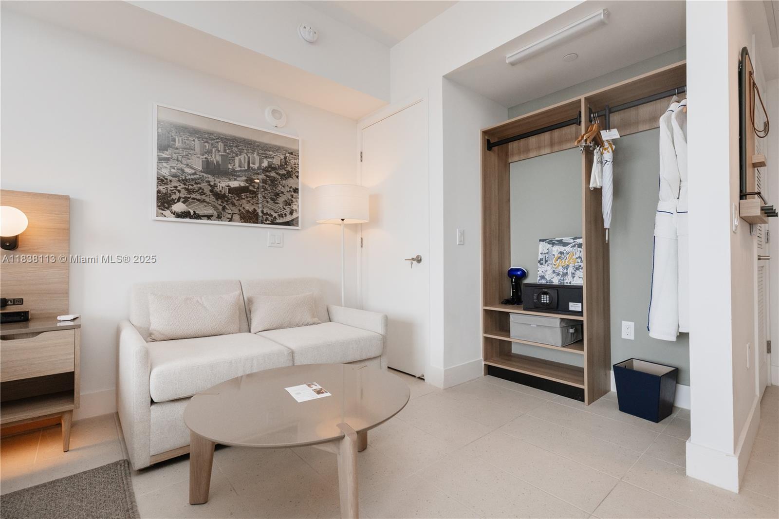 A hotel room features a sofa, a coffee table, and an open-concept wooden closet — 601 NE 1st ave # 3612, Miami FL 33132, MIAMI, FL