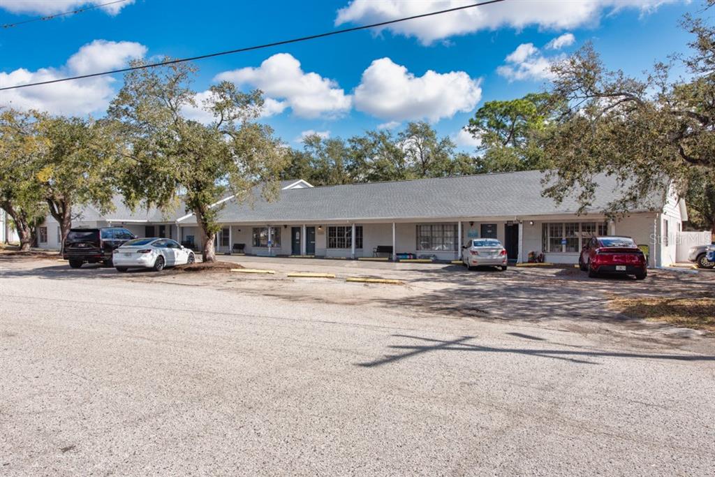 A single-story commercial building with a long covered porch and a gravel parking lot — 7414 COMMERCE STREET UNIT 102, RIVERVIEW, FL