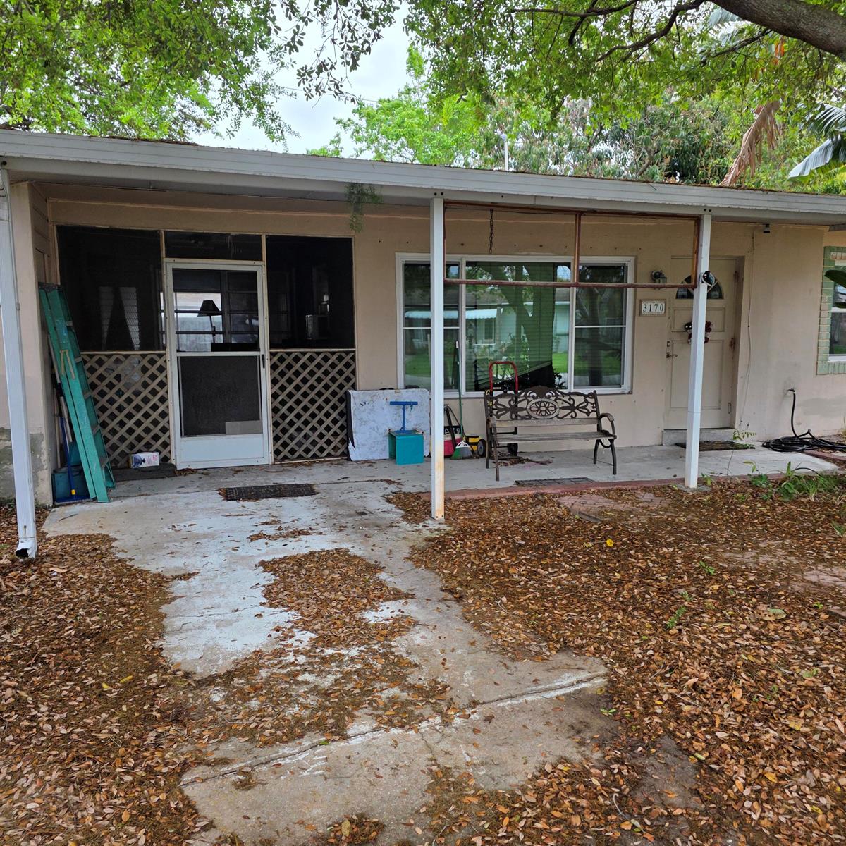 A single-story house exterior features a concrete patio, a screened porch, and a front door — 3170 NE 10th Terrace, Pompano Beach FL 33064, POMPANO BEACH, FL