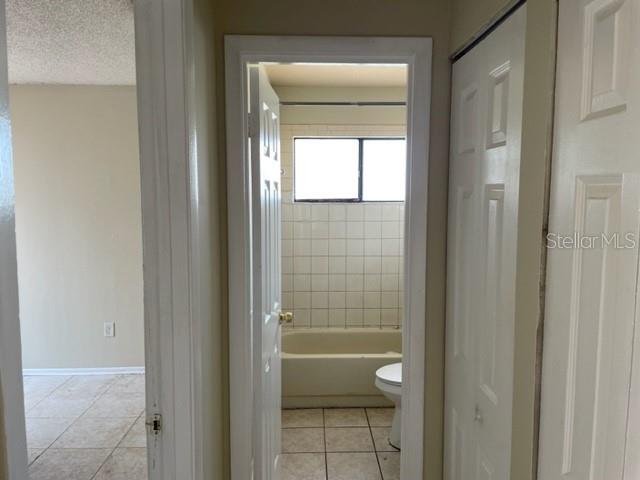 A hallway leads to a bathroom with a tiled tub and shower combination — 4721 ALMOND WILLOW DRIVE, ORLANDO, FL